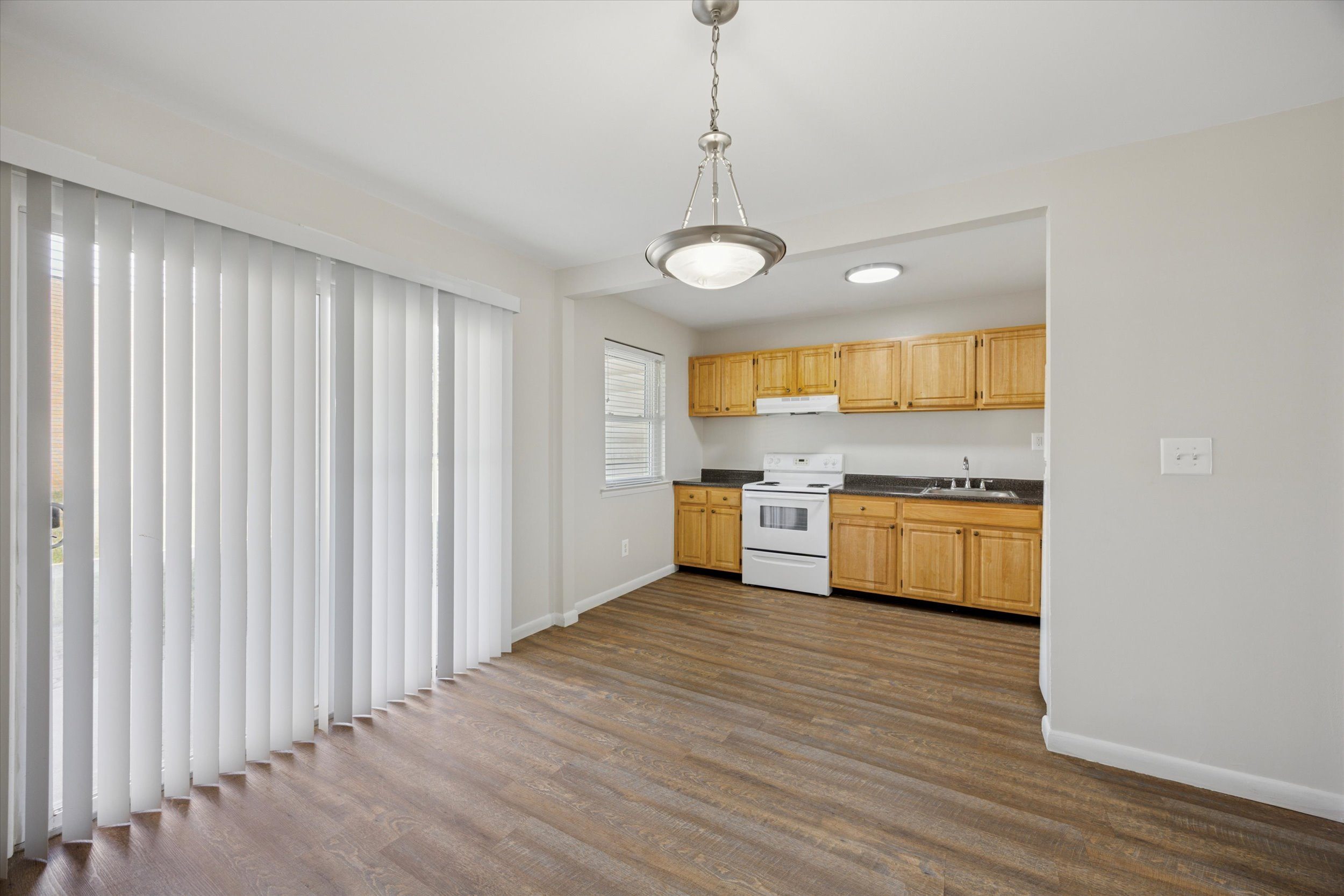 A kitchen with wooden floors and white walls.